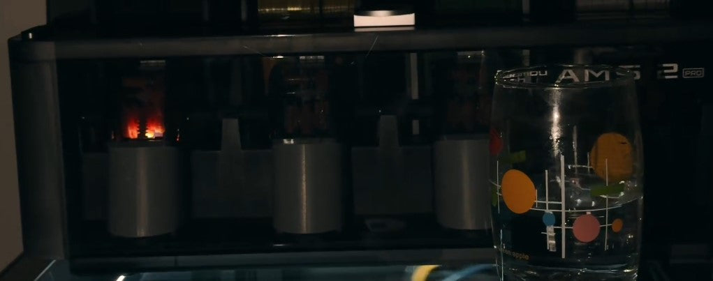 A glass cup placed on top of the Bambu Lab P2S shows the shaking issue