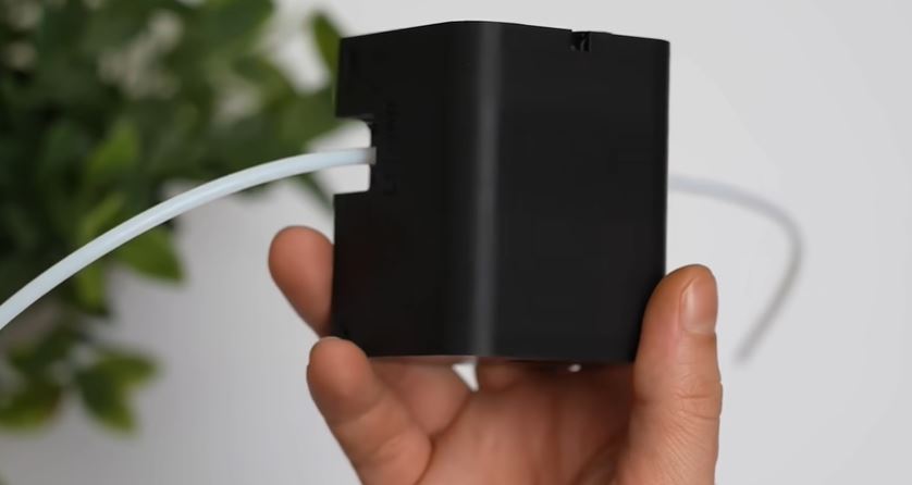 Hand holding Bambu Lab’s TPU Feed Assist Module for a close-up look at the TPU feeding accessory.