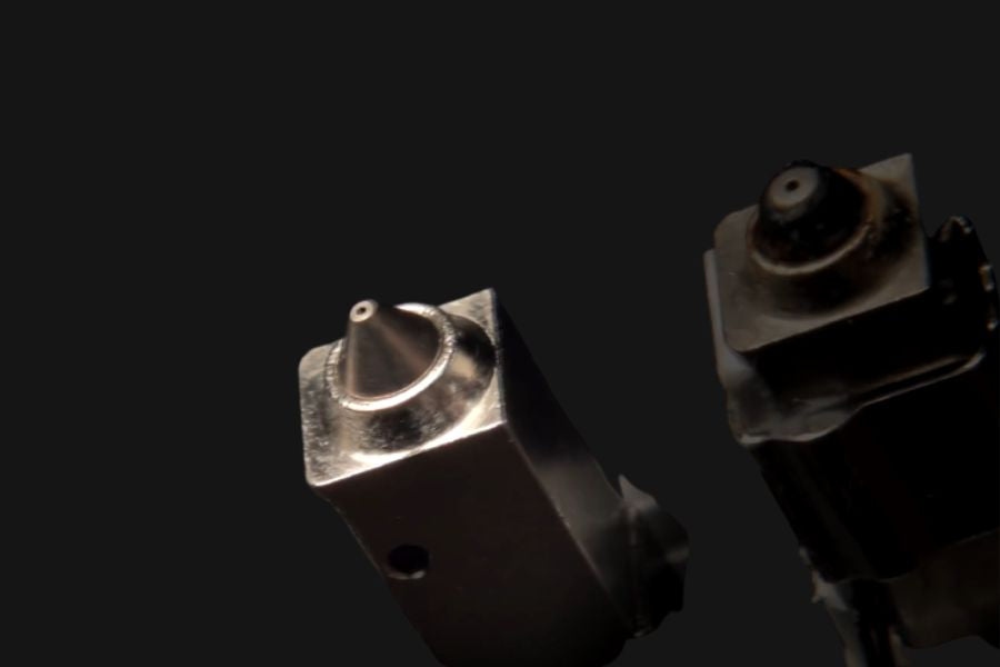Worn Bambu Lab nozzle next to a new replacement nozzle