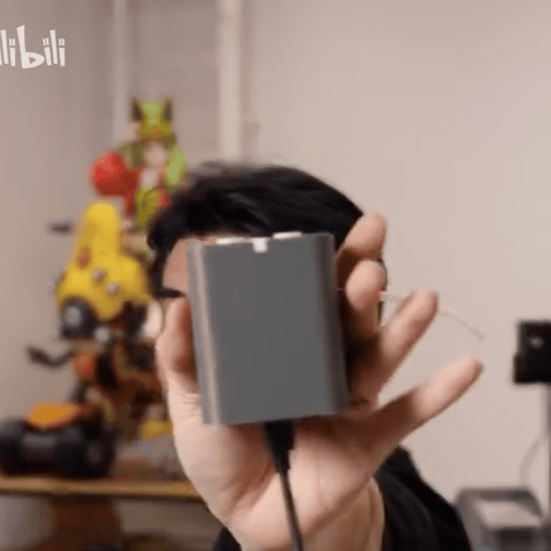 Hand holding Bambu Lab’s TPU Feed Assist Module for a close-up look at the TPU feeding accessory
